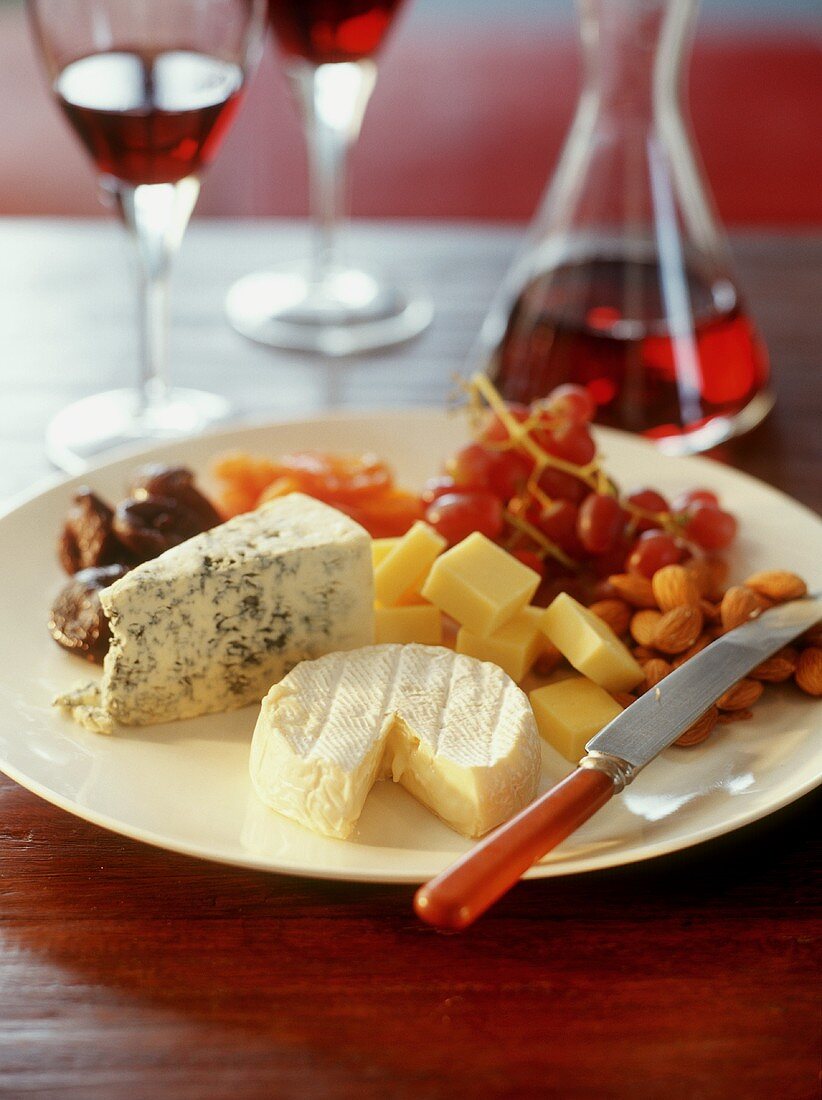 Plate of cheese with almonds and grapes