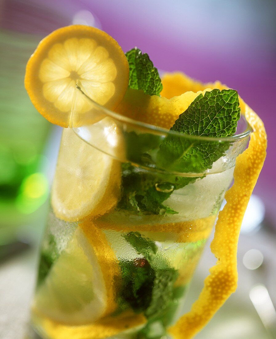 Water with slices of lemon, ice cubes and mint leaves