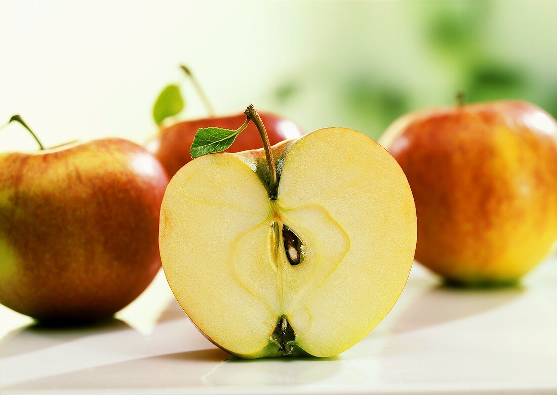 Half an apple in front of apples