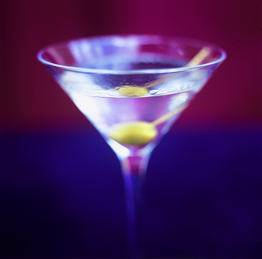A glass of Martini with green olive
