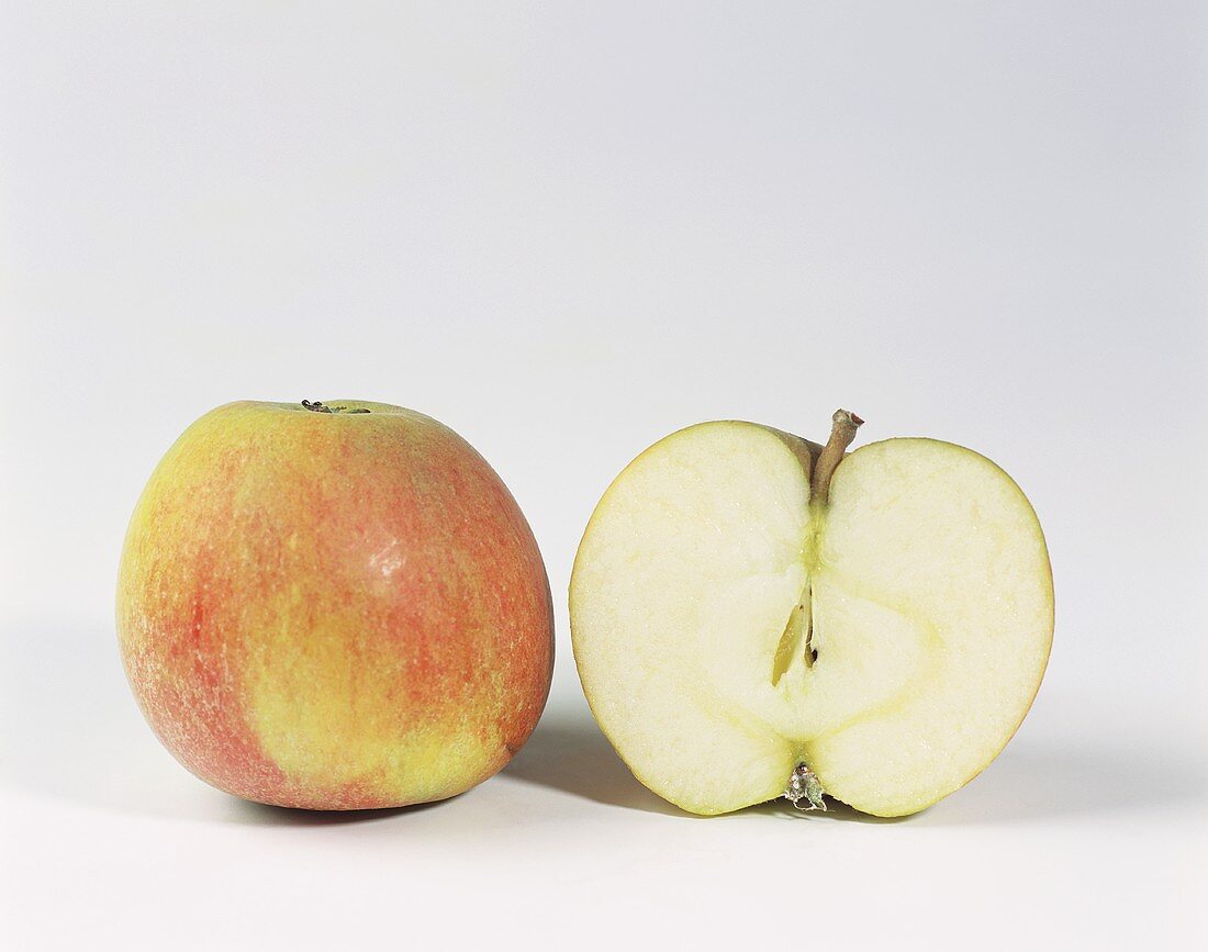 Ein ganzer und ein halber Apfel der Sorte Cox Orange