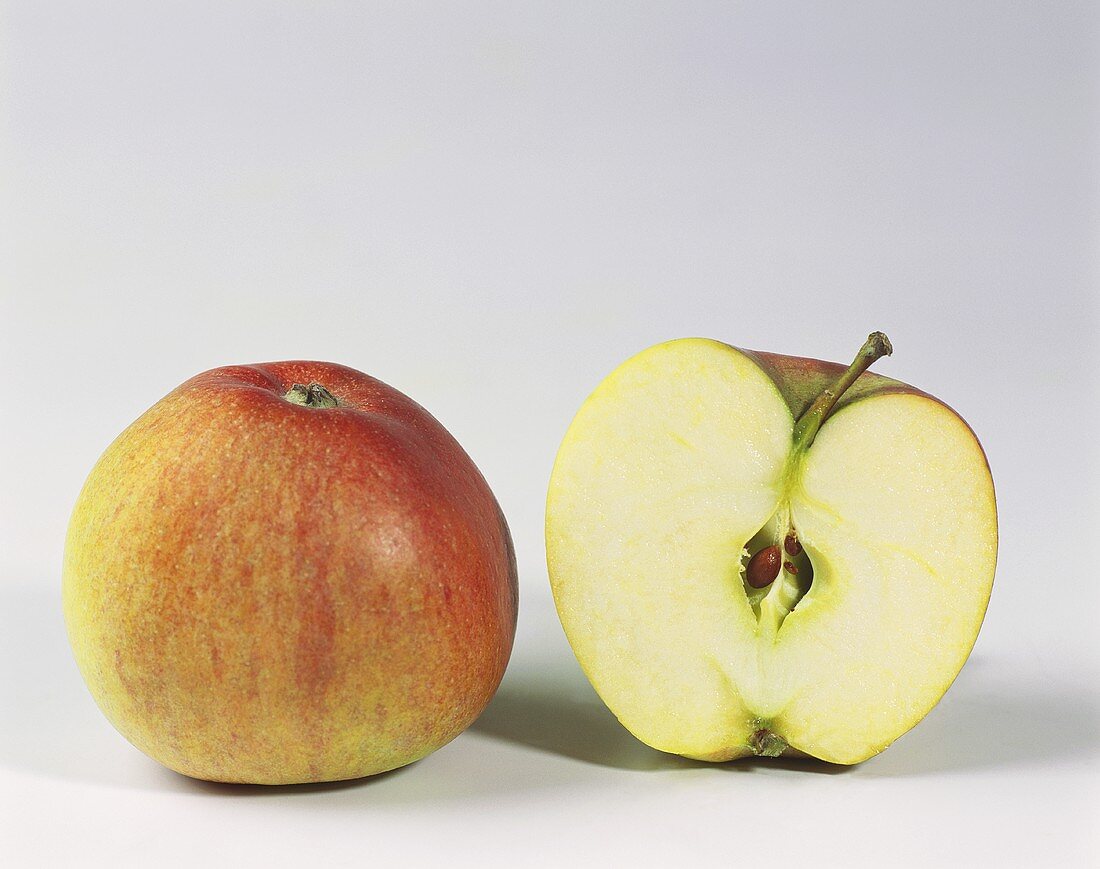 Ein ganzer und ein halber Apfel der Sorte Braeburn