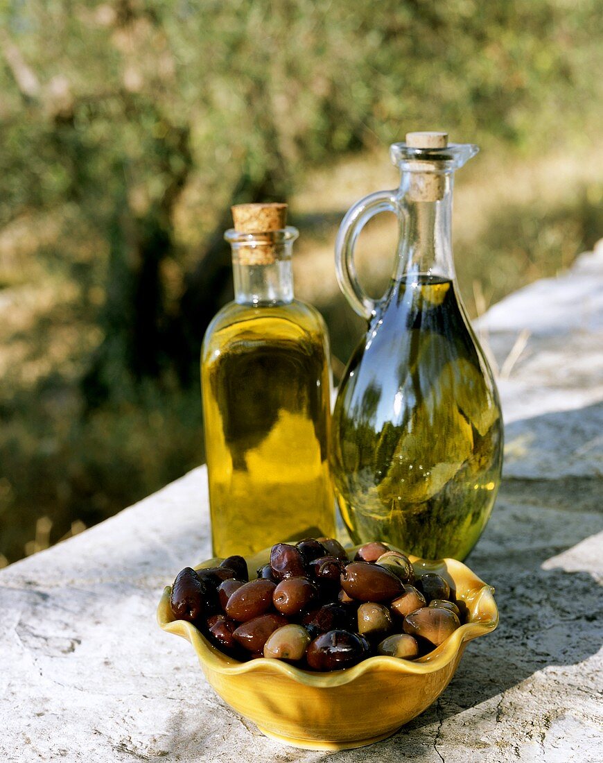 Olivenöl mit Oliven im Freien
