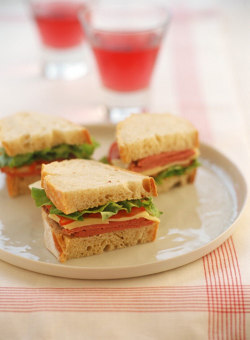 Sandwiches mit Corned Beef, Käse und Salat belegt