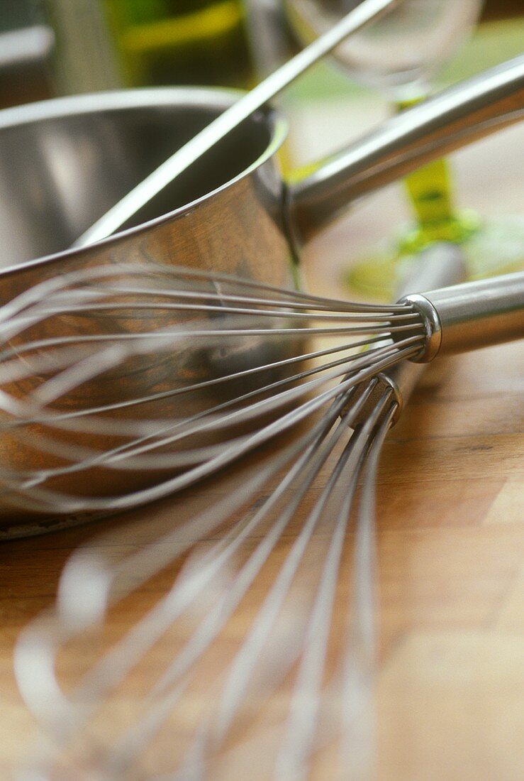 Kitchen scene: egg whisk and pan on work surface