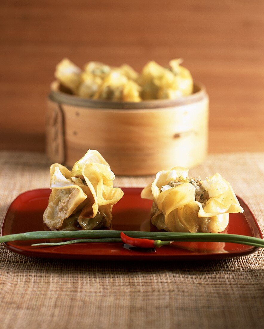 Dim sum (Chinese pastry purses) on platter and in steamer