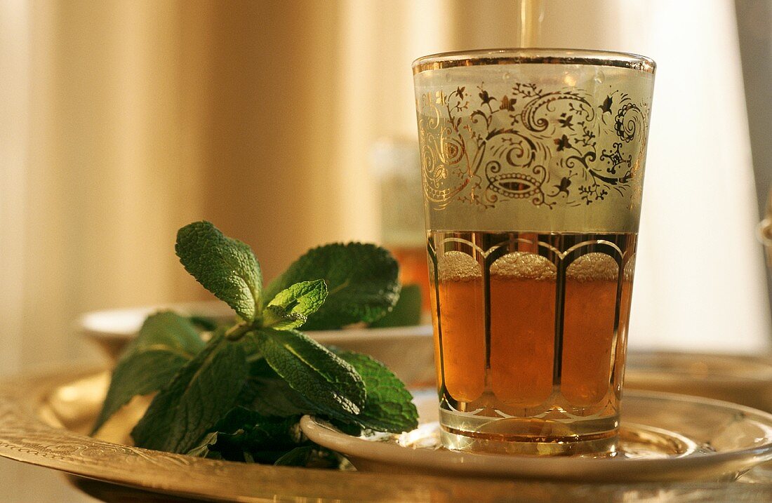 Peppermint tea in Middle Eastern glass & fresh mint leaves