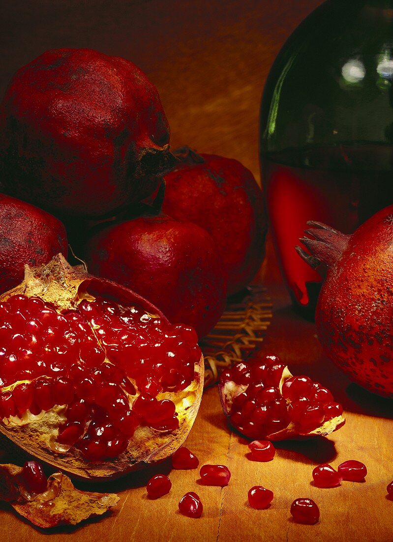 Opened pomegranate in front of whole pomegranates