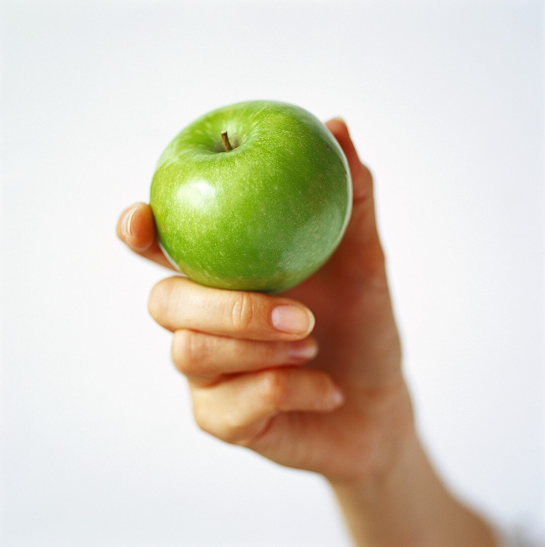 Hand hält einen grünen Apfel