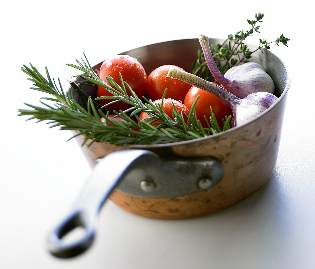 Tomatoes, garlic and herbs in a pan