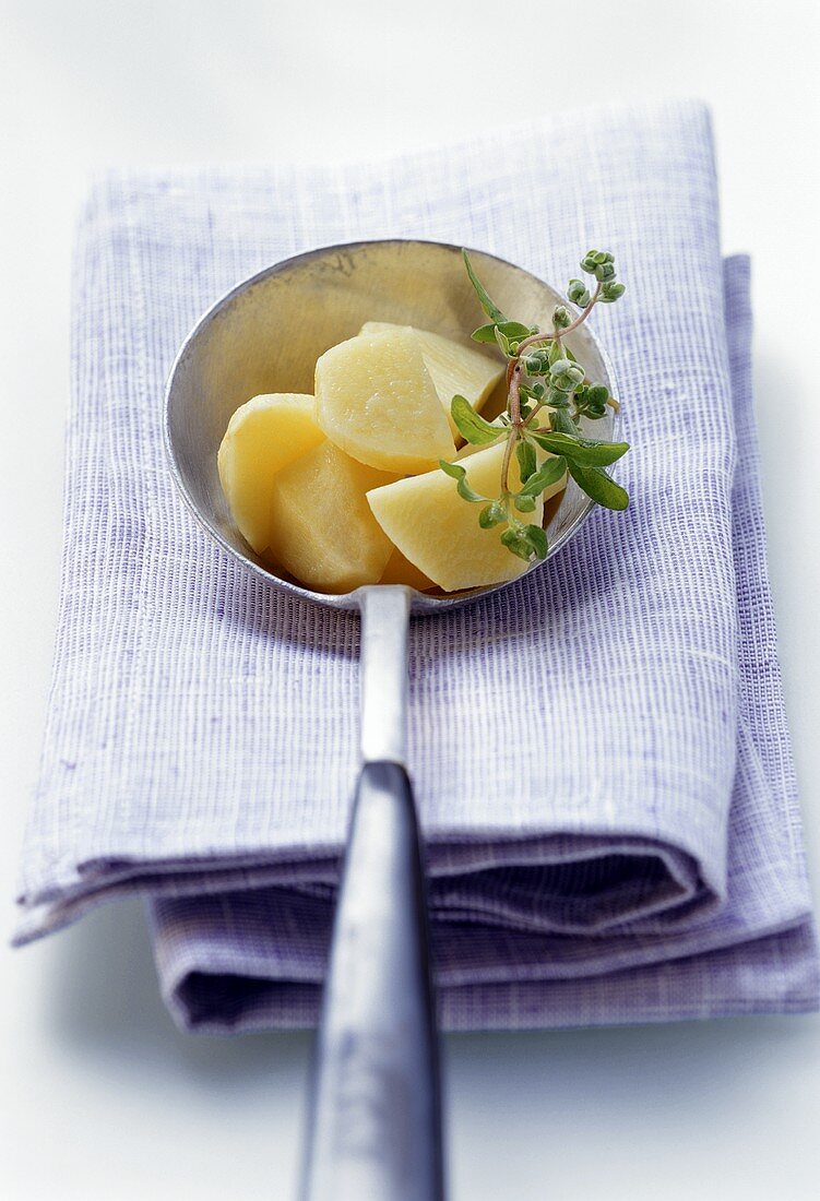 Cooked potatoes with herbs in ladle