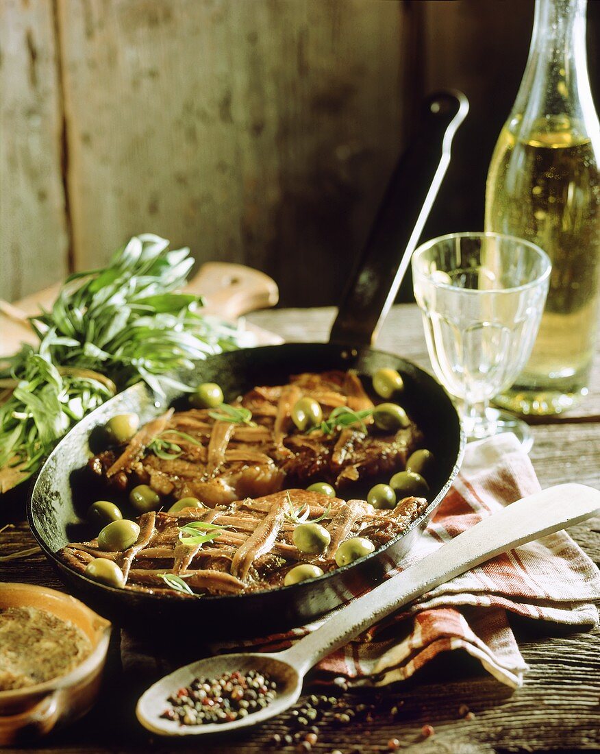 Beef steaks with anchovies and green olives