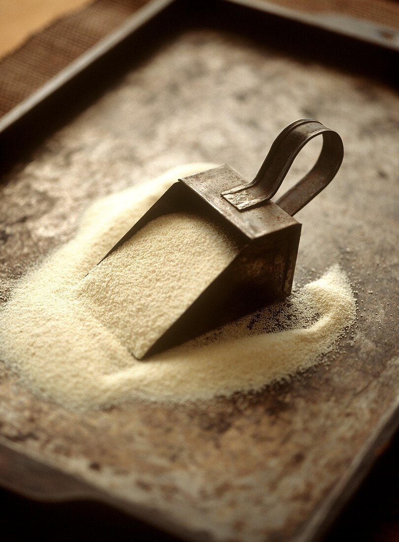 Flour scoop with semolina on a baking tray