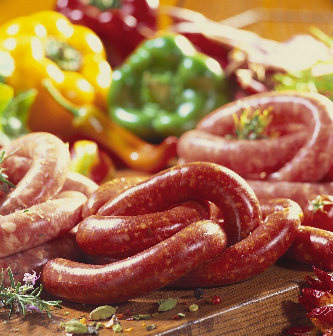 Various types of raw sausages, peppers behind