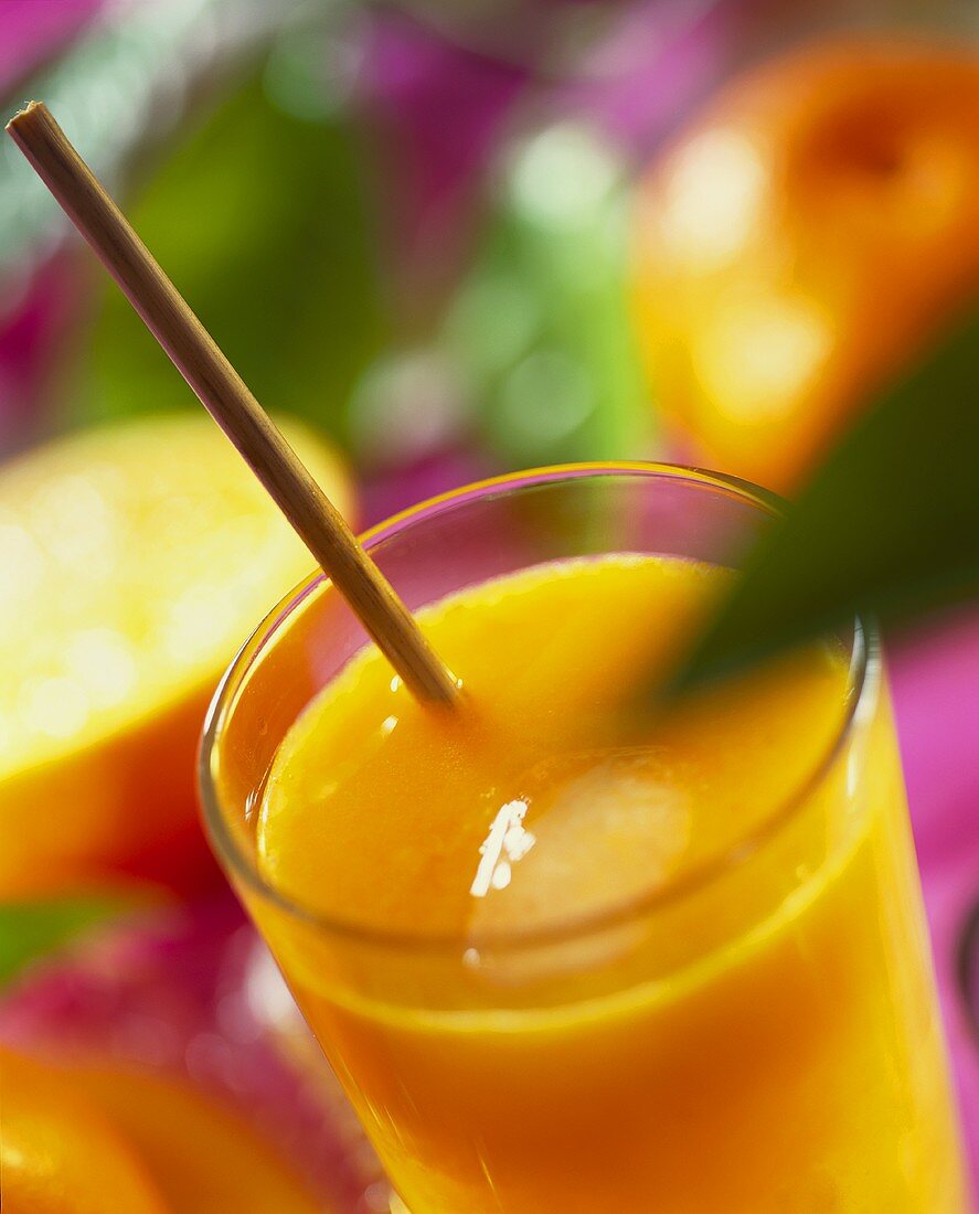 Freshly squeezed orange juice with ice cube & drinking straw