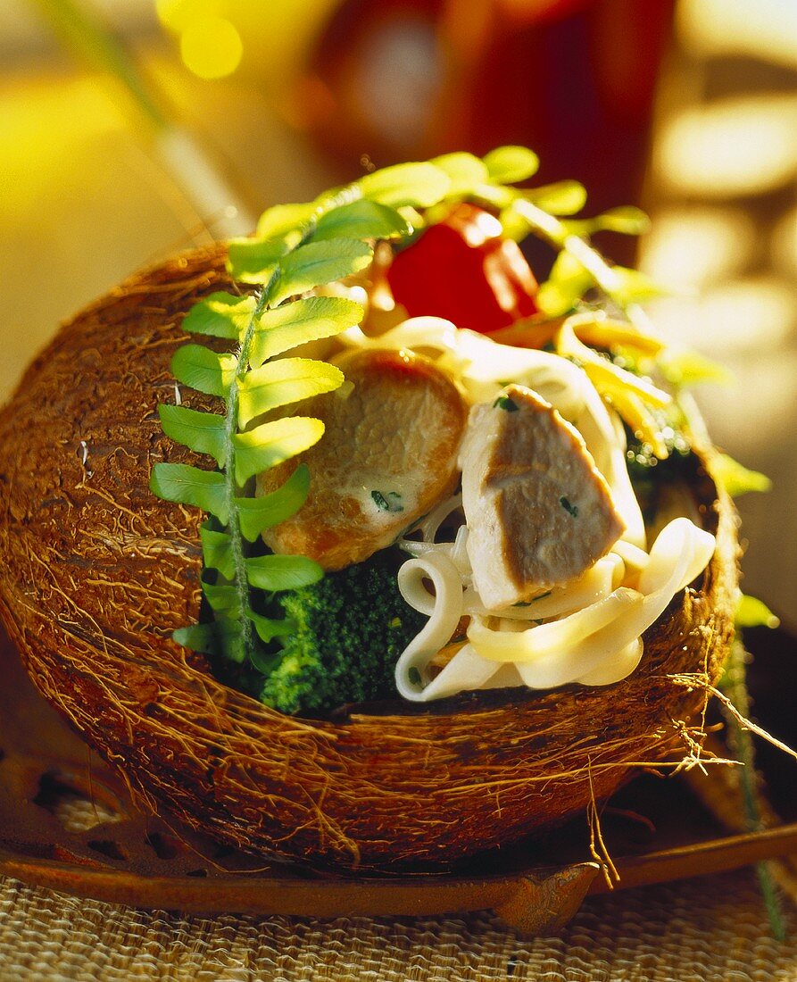 Schweinefilets mit Bandnudeln und Gemüse in einer Kokosnuss