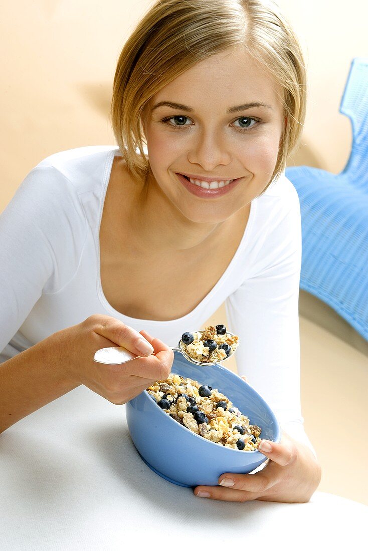 Young woman with fresh berry muesli