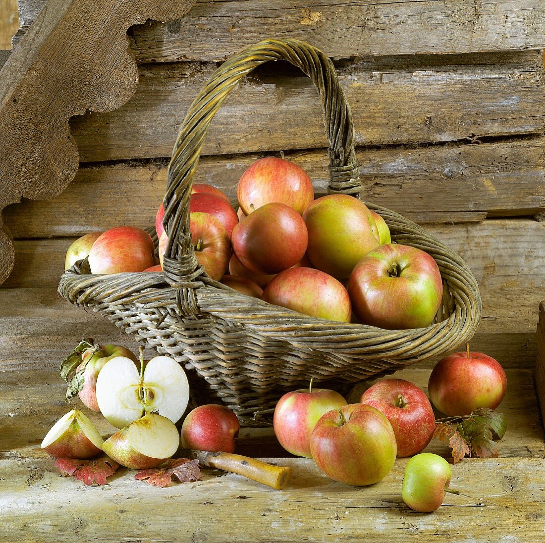 Apples in and in front of basket
