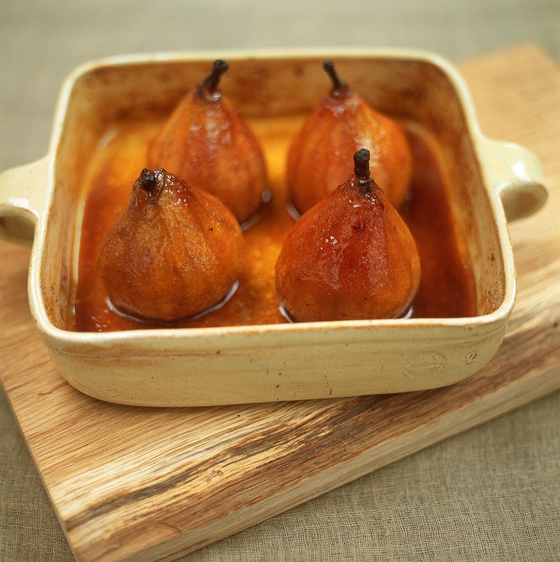 Four baked pears with honey in baking dish