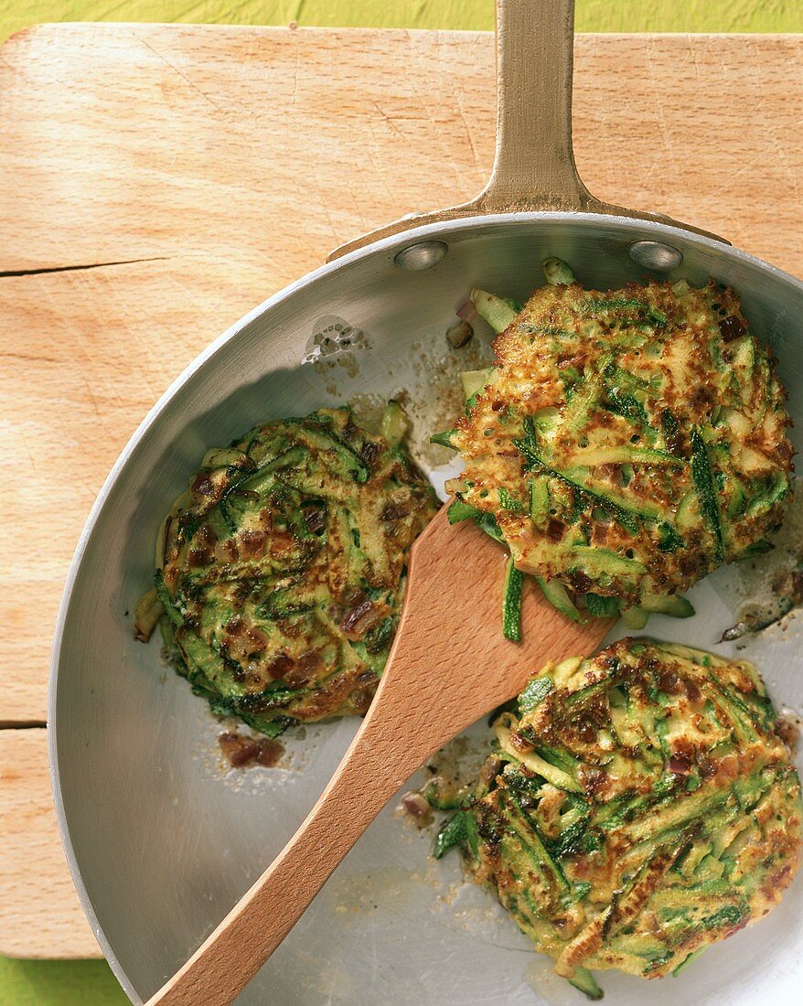 Three courgette cakes in the frying pan