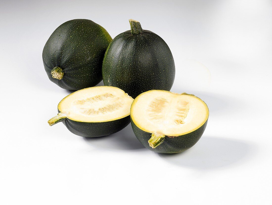 Two whole and two half round courgettes