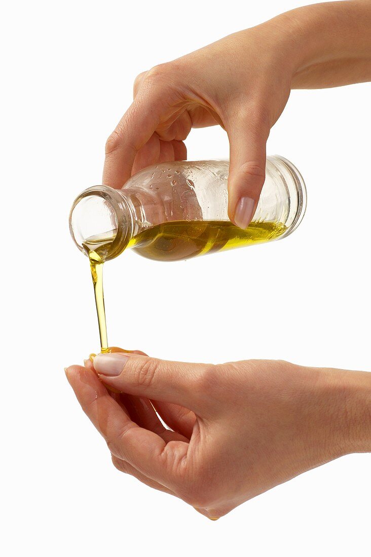 Woman pouring oil onto her hand