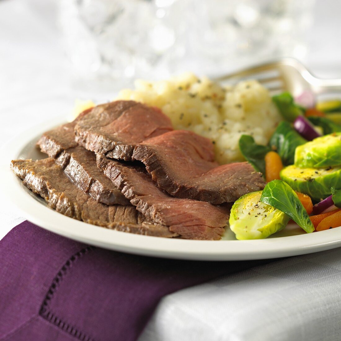 Vier Roastbeefscheiben mit Kartoffelsalat und Rosenkohl