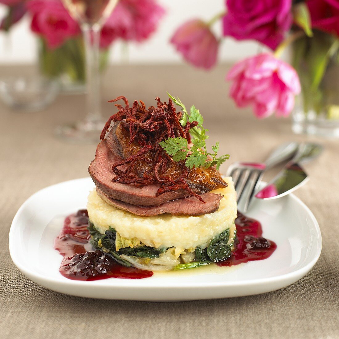 Thin slices of duck on vegetable puree with cranberries