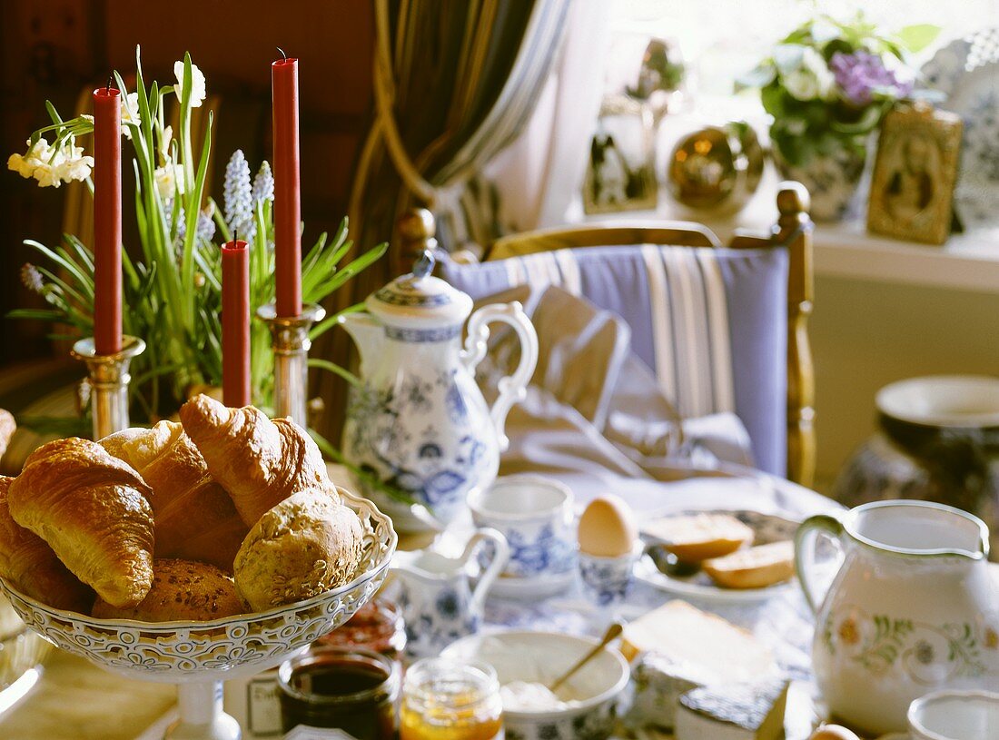 Breakfast table with pastries, jams, egg and coffee