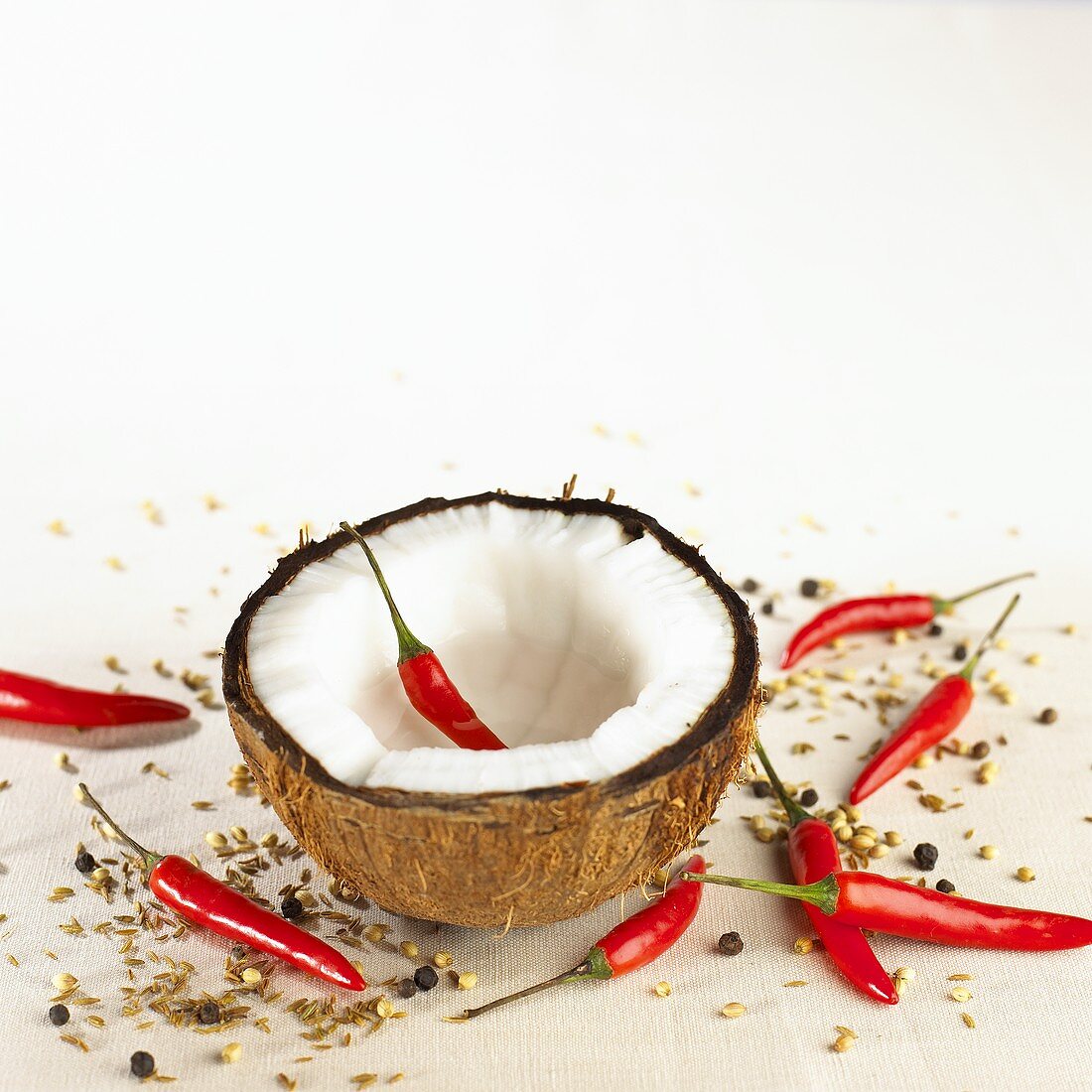 Coconut half with chili peppers and spices