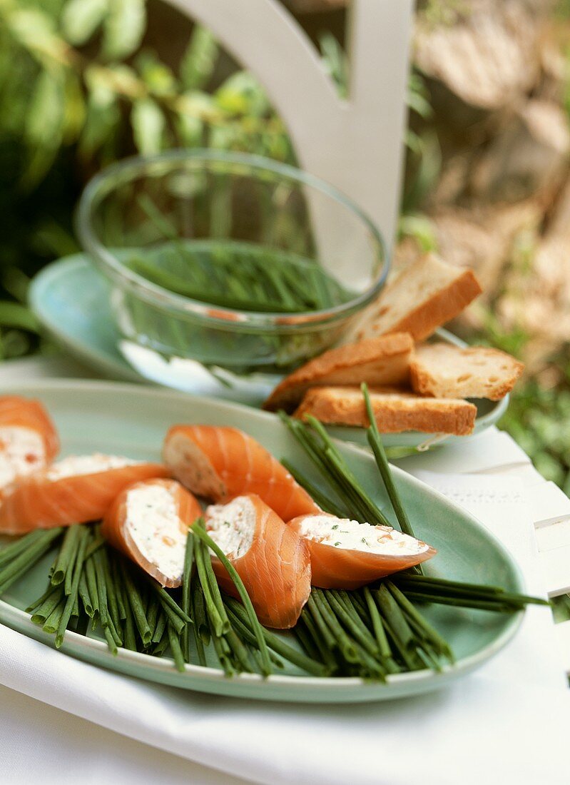 Salmon roulade with soft cheese filling on chives