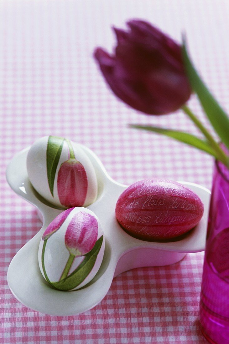 Eggcups with three eggs and purple tulip