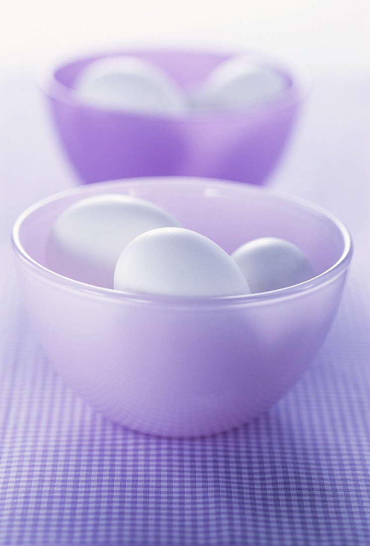 Two purple bowls with white eggs