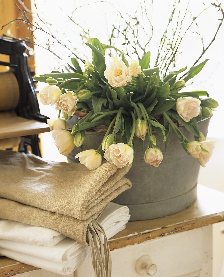 Still life with folded washing and bouquet of tulips