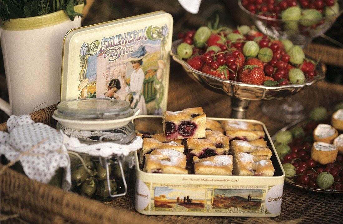 Picknickkorb mit Oliven, Kirschkuchen und Beeren