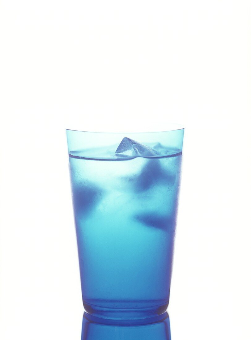 Mineral water with ice cubes in blue glass