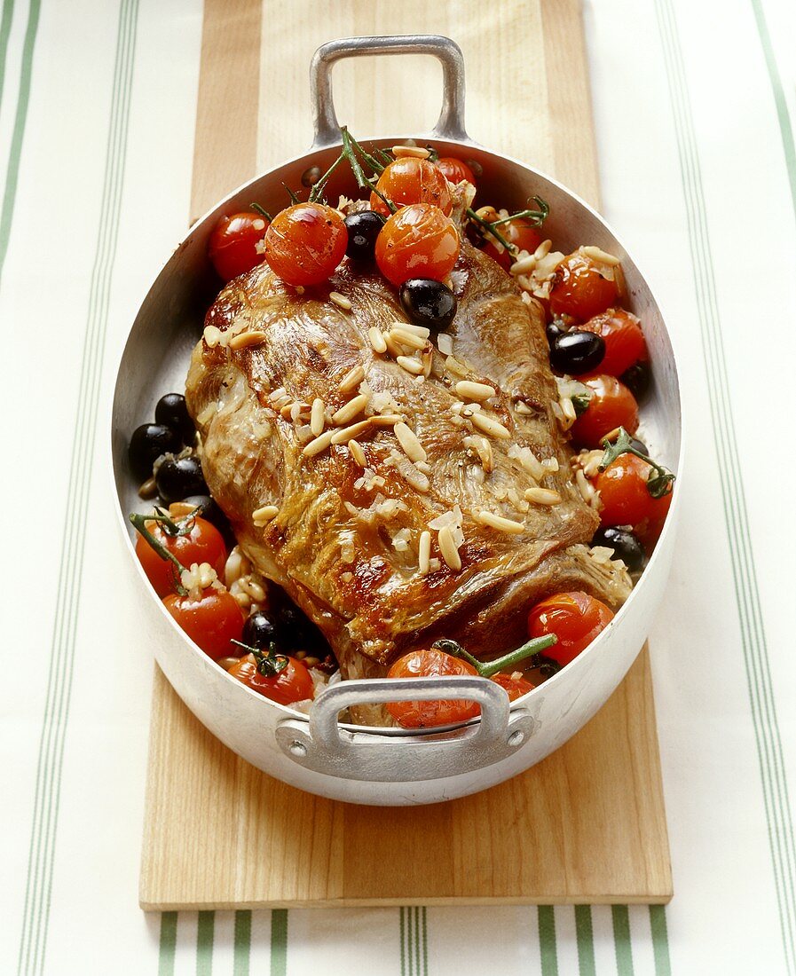 Shoulder of lamb with tomatoes, olives, pine nuts in meat dish