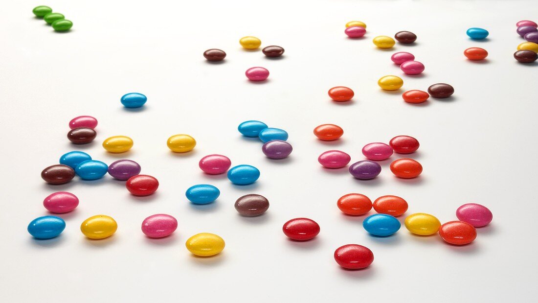 Coloured chocolate beans on white background