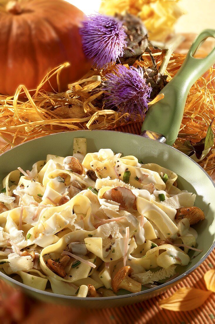 Pan-cooked pasta dish with chanterelles & cheese, autumn décor