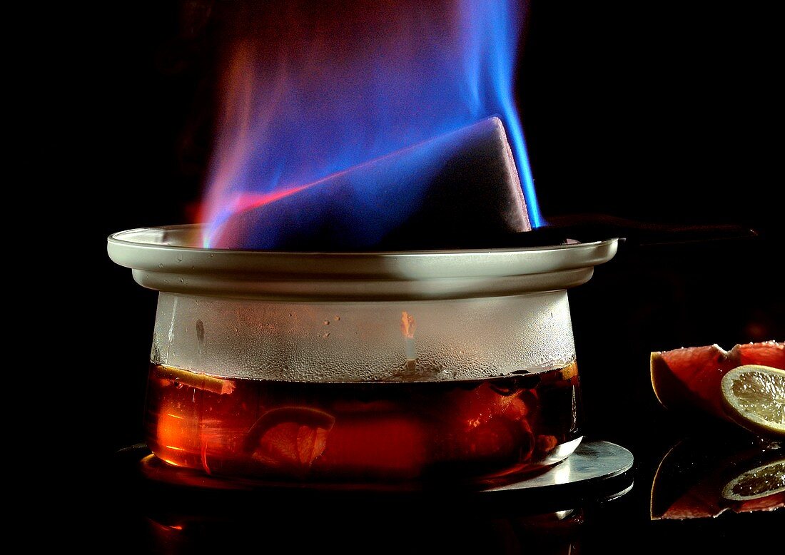 Feuerzangenbowle mit brennendem Zuckerhut