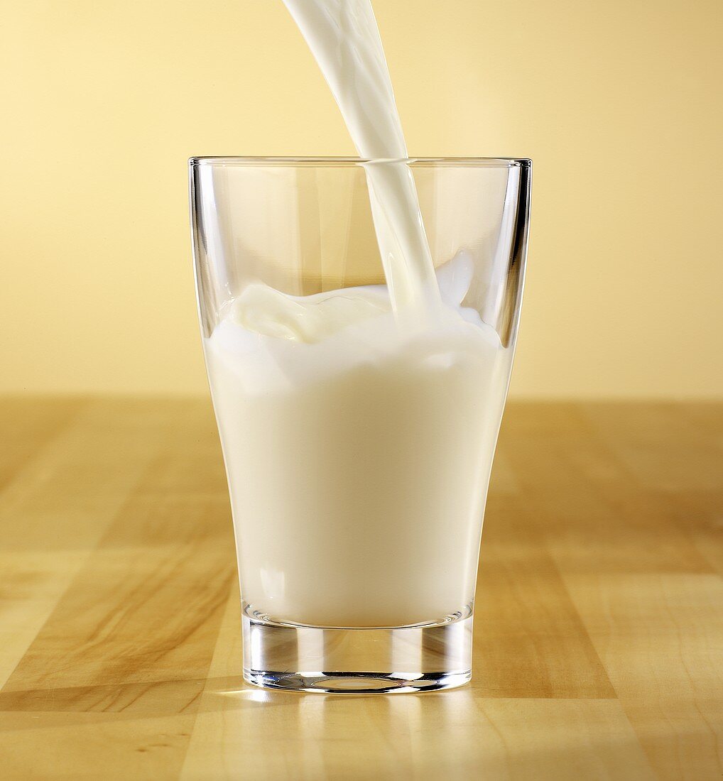 Milch in ein Glas gießen