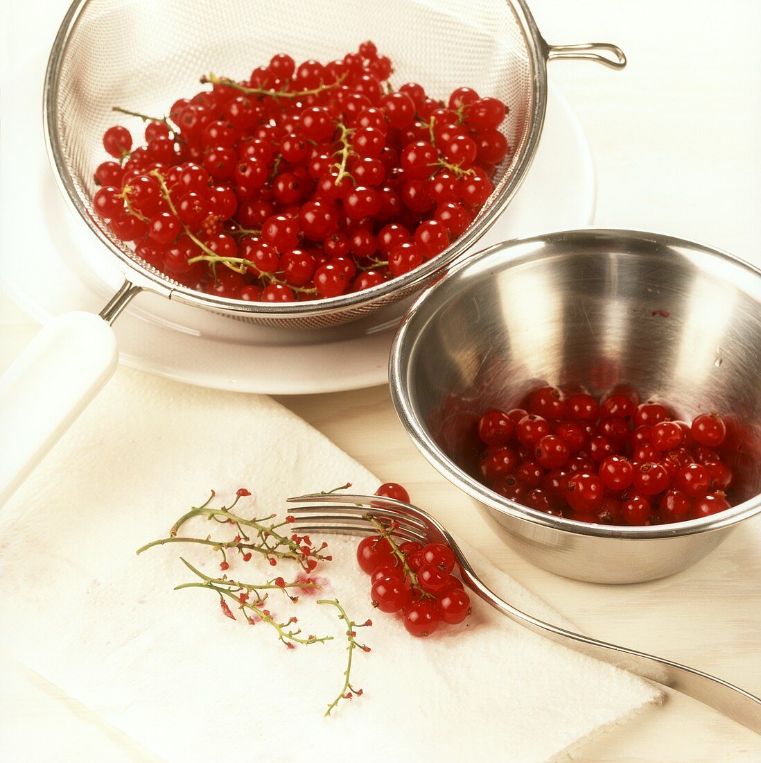 Rote Johannisbeeren mit Gabel von der Rispe gezogen