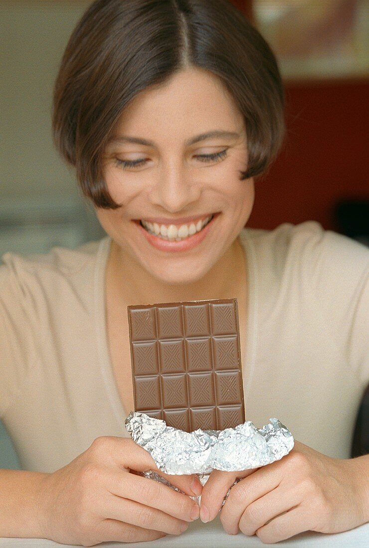 Woman holding a bar of chocolate (grainy effect)