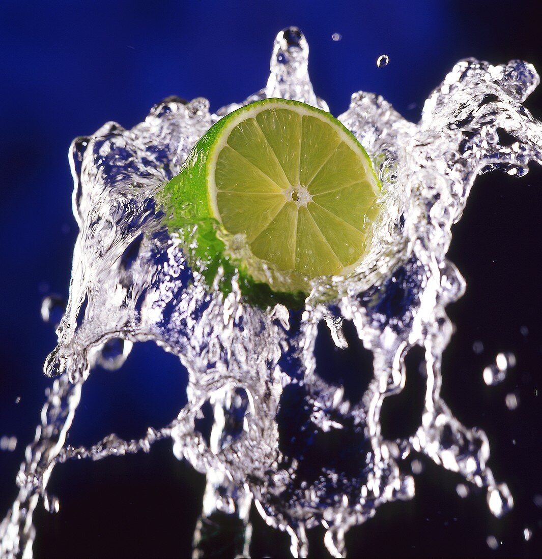 Slice of lime on splashing water