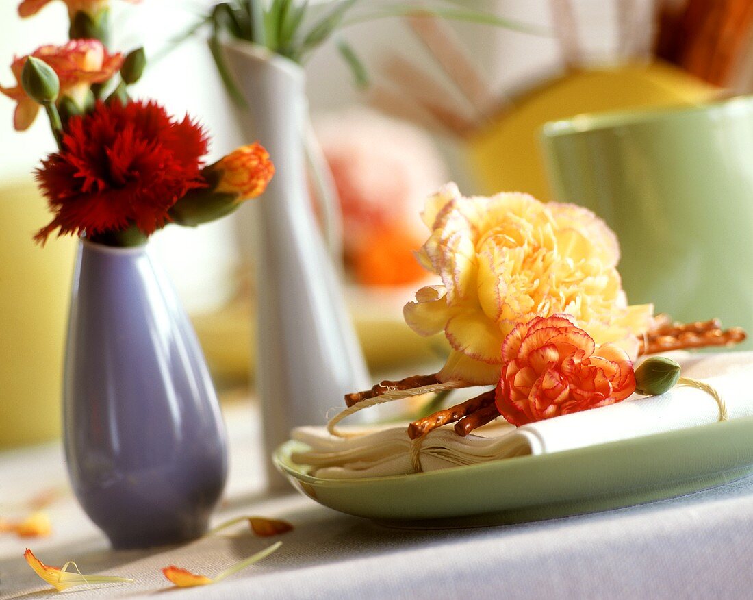 Tischdeko mit Nelkenblüten,in der Vase und mit Salzstangen