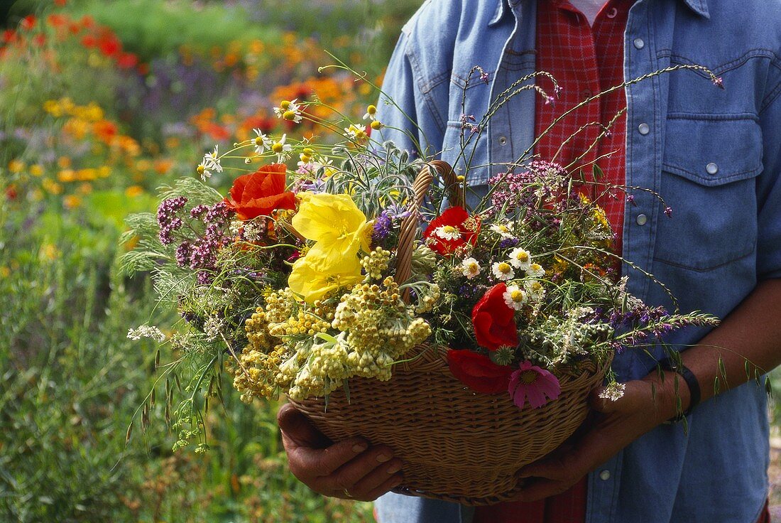 Woman with basket full of flowers and grasses