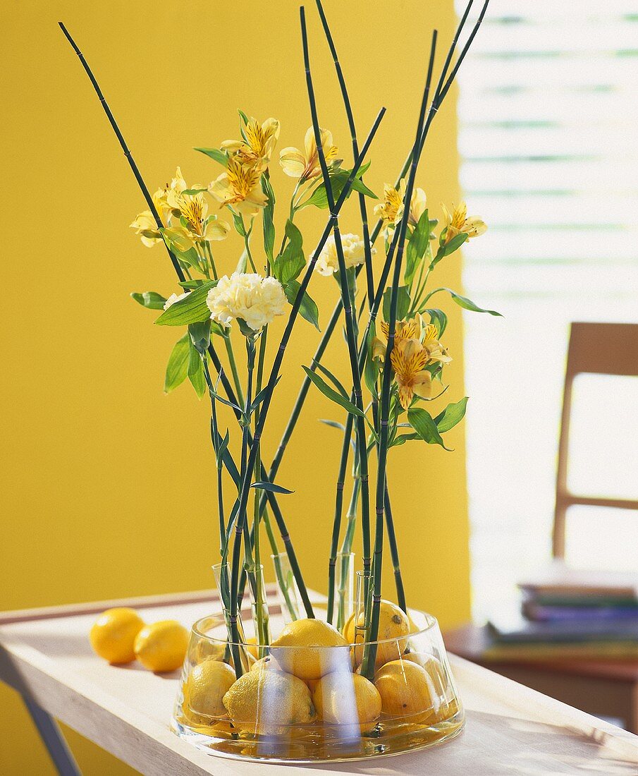 Arrangement of lemons, Peruvian lilies & yellow carnations 