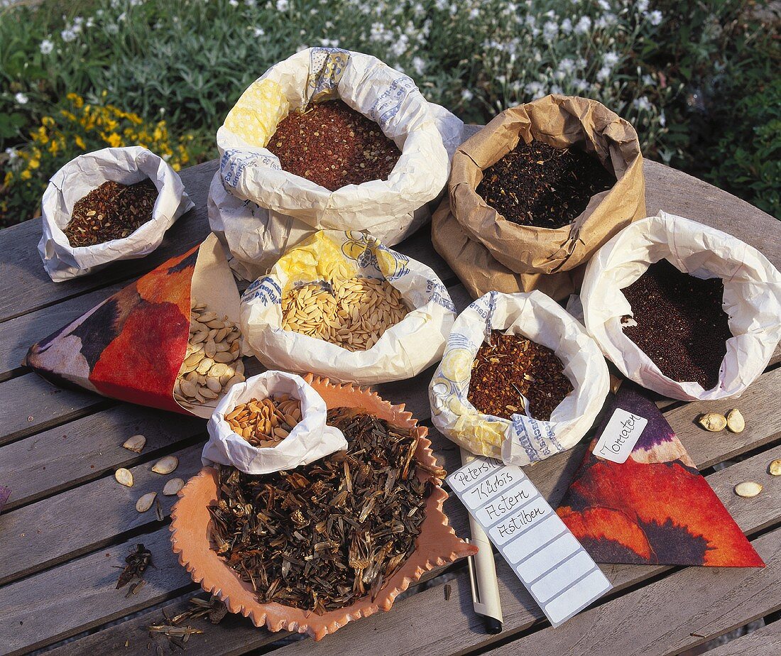 Various plant seeds in paper bags; labels beside them