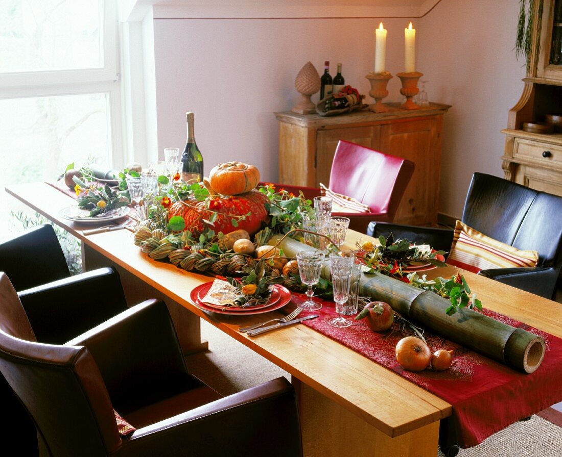 Herbstlich gedeckter Esstisch mit Kürbissen und langem Bambusrohr