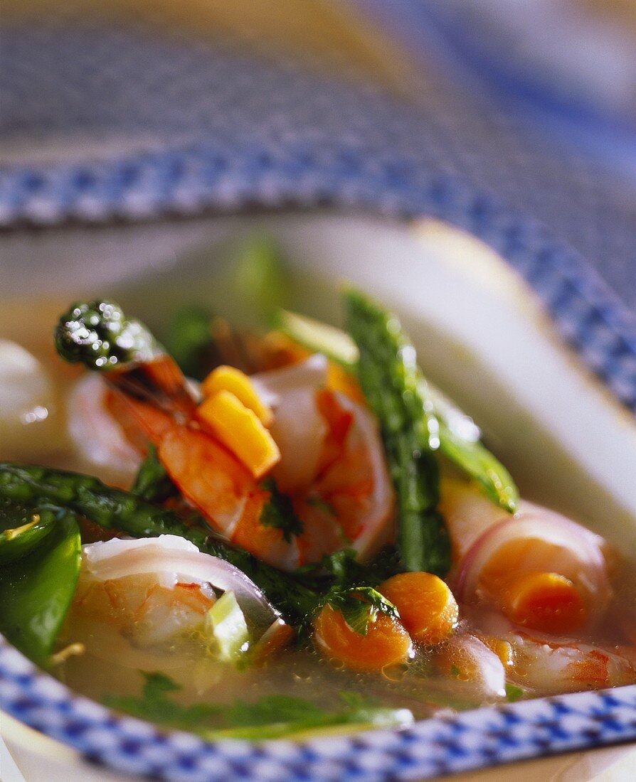 Vegetable broth with green asparagus and shrimps